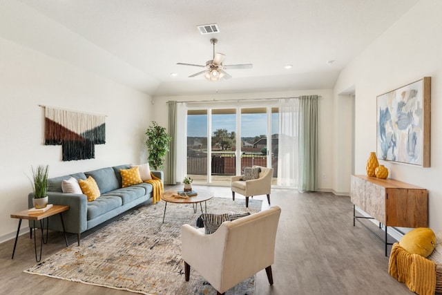 living room featuring visible vents, wood finished floors, baseboards, and ceiling fan