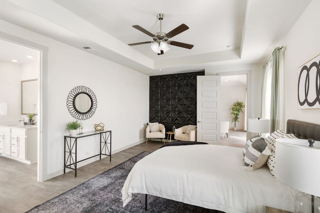 1837 Flying Horseshoe Bnd, Georgetown, TX 78628 - bedroom with a tray ceiling, ensuite bathroom, baseboards, and ceiling fan