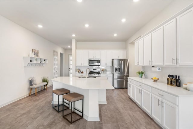 1837 Flying Horseshoe Bnd, Georgetown, TX 78628 - kitchen with appliances with stainless steel finishes, a sink, a kitchen island with sink, white cabinetry, and recessed lighting