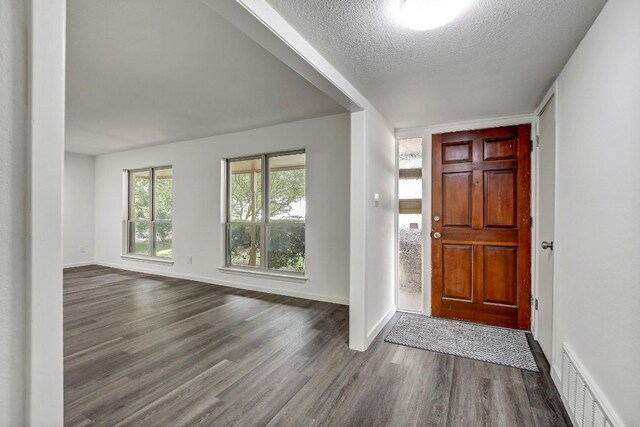 entryway featuring a textured ceiling and dark wood-type flooring