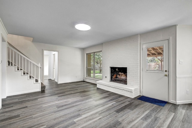 unfurnished living room featuring a fireplace and dark hardwood / wood-style flooring