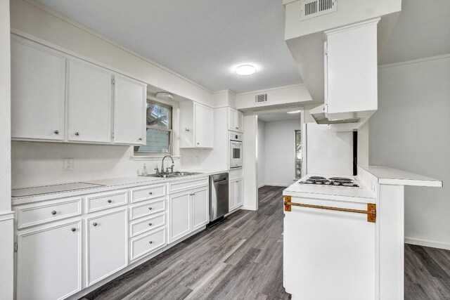 kitchen with sink, dark hardwood / wood-style flooring, crown molding, white appliances, and white cabinets