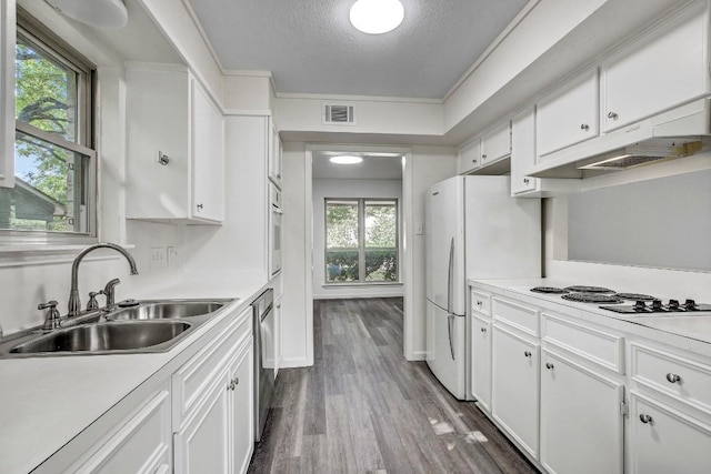 kitchen featuring white appliances, a sink, visible vents, and white cabinets