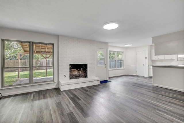 unfurnished living room featuring dark wood finished floors, a fireplace, and baseboards