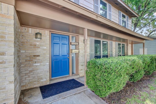 view of exterior entry with brick siding