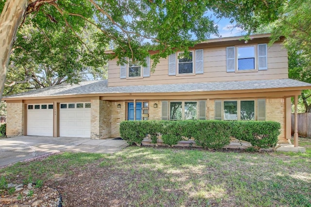 traditional-style home with brick siding, a shingled roof, a garage, driveway, and a front lawn