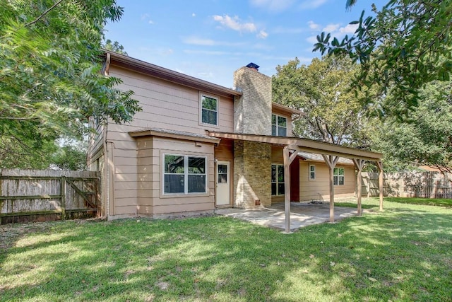 rear view of property featuring a patio, a yard, a chimney, and fence