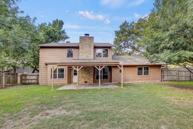 rear view of house with a lawn, a patio area, and a fenced backyard