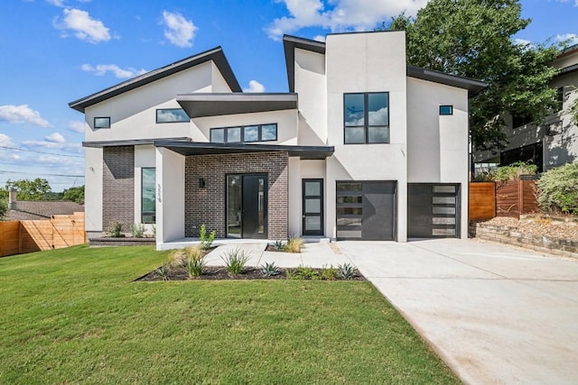 contemporary house featuring a garage, brick siding, fence, driveway, and stucco siding