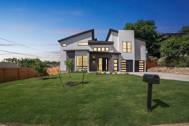 contemporary house featuring a lawn and a garage