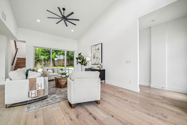 living room featuring ceiling fan, light wood-type flooring, and high vaulted ceiling