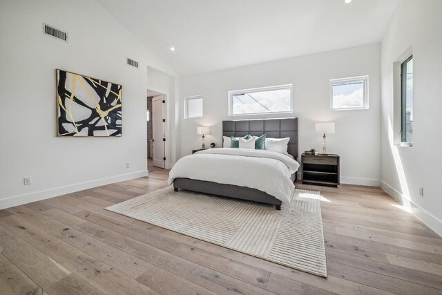 bedroom with light hardwood / wood-style floors and lofted ceiling