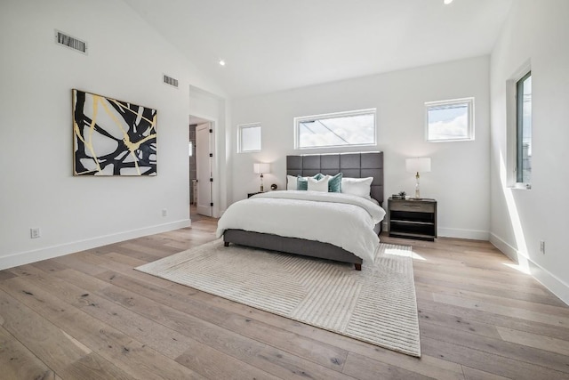 bedroom with light wood-style flooring, visible vents, and baseboards