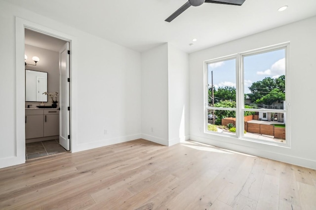 unfurnished bedroom with recessed lighting, light wood-style flooring, and baseboards