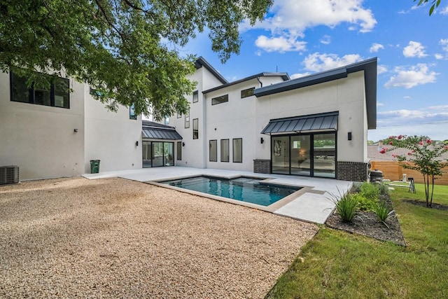 back of house featuring metal roof, an outdoor pool, stucco siding, a standing seam roof, and a patio area