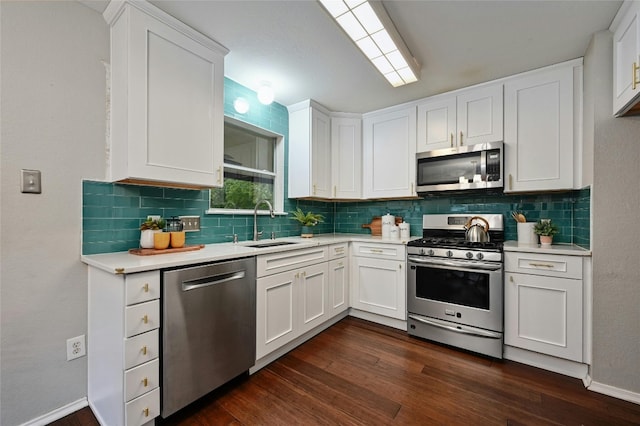 kitchen with dark wood finished floors, light countertops, white cabinetry, and appliances with stainless steel finishes