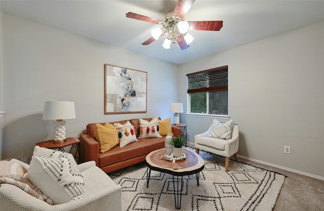 carpeted living room featuring baseboards and ceiling fan