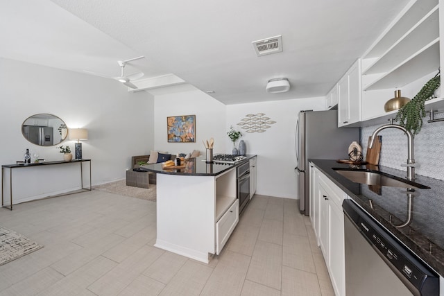 kitchen with a breakfast bar, sink, white cabinetry, appliances with stainless steel finishes, and kitchen peninsula