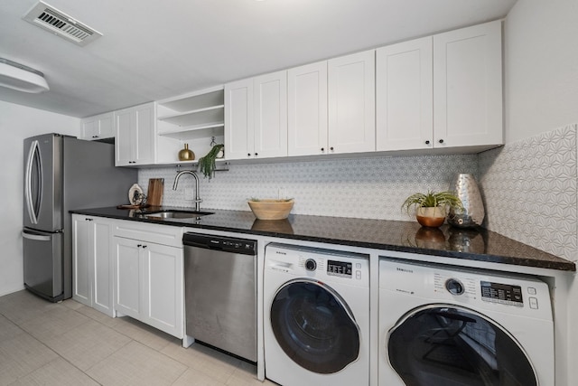 clothes washing area featuring separate washer and dryer and sink