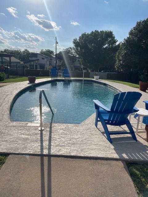 view of swimming pool with pool water feature and a patio