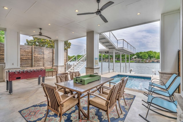 view of patio featuring an outdoor hangout area, a water view, a fenced in pool, pool water feature, and ceiling fan