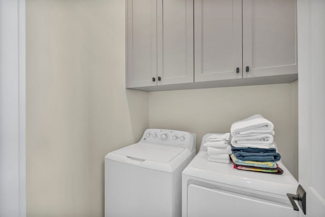 laundry area with cabinets and washing machine and dryer