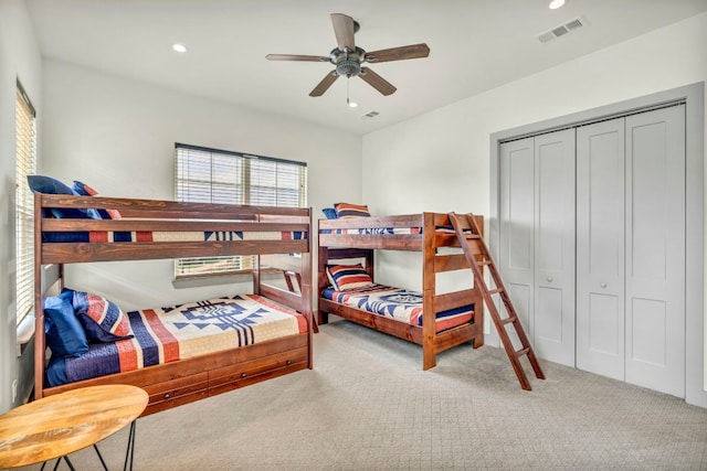 carpeted bedroom featuring a closet and ceiling fan