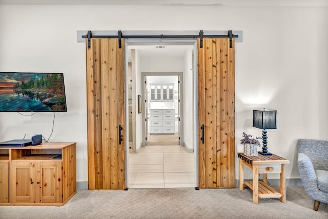 interior space featuring a barn door and light tile floors