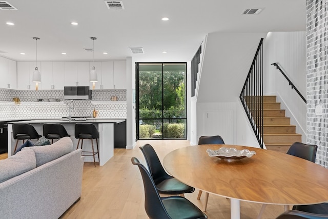 dining space with sink, plenty of natural light, and light hardwood / wood-style flooring