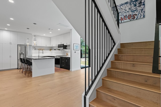 stairs with light hardwood / wood-style flooring