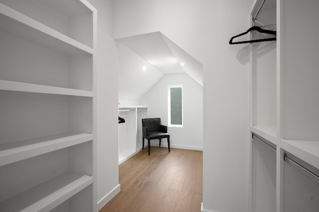 walk in closet featuring vaulted ceiling and light wood-type flooring