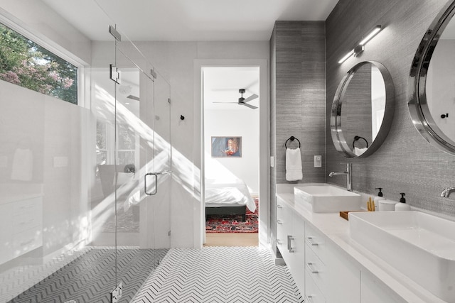 bathroom featuring ceiling fan, dual vanity, tile walls, walk in shower, and tile floors