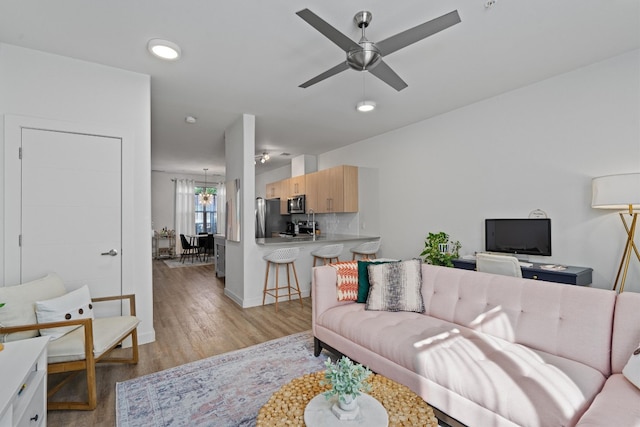 living room with light hardwood / wood-style floors and ceiling fan