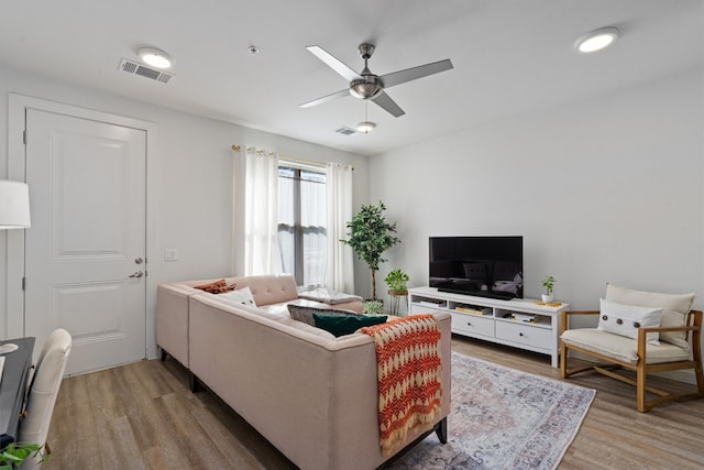 living room with wood-type flooring and ceiling fan