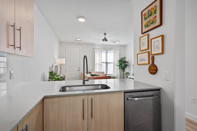 kitchen featuring light brown cabinetry, dishwasher, light hardwood / wood-style flooring, and sink