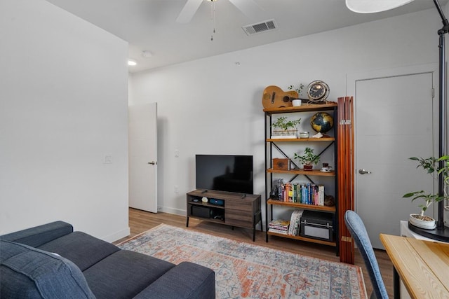 living room featuring ceiling fan and hardwood / wood-style floors