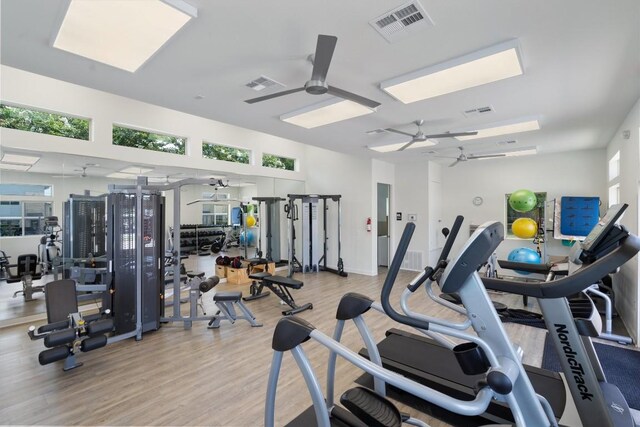 gym with light hardwood / wood-style floors and ceiling fan