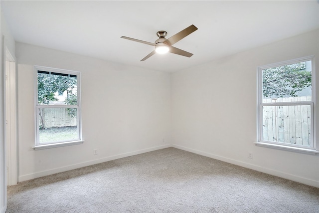 carpeted spare room featuring ceiling fan and a healthy amount of sunlight