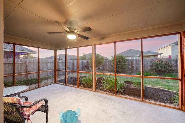 unfurnished sunroom featuring ceiling fan