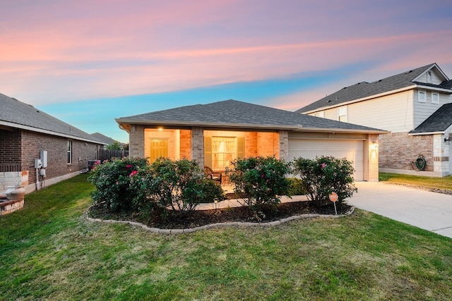 view of front of house with a garage and a yard