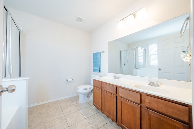 bathroom featuring tile patterned flooring, vanity, toilet, and a shower with shower door