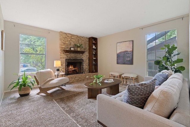 carpeted living room featuring a healthy amount of sunlight and a stone fireplace