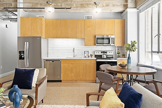 kitchen featuring stainless steel appliances, a healthy amount of sunlight, hanging light fixtures, and sink