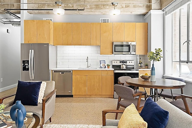 710 Colorado St Unit 2A, Austin, TX 78701 - kitchen with stainless steel appliances, a sink, backsplash, light countertops, and light brown cabinets