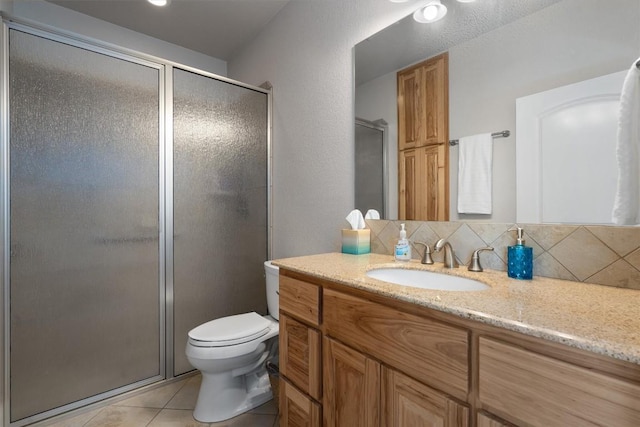 bathroom featuring tile patterned flooring, vanity, decorative backsplash, and a shower with shower door