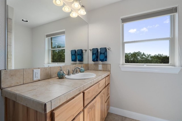 bathroom with vanity, a wealth of natural light, and tile patterned floors