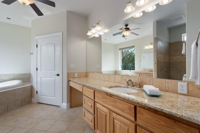 bathroom featuring a relaxing tiled tub, ceiling fan, vanity, and tile patterned flooring