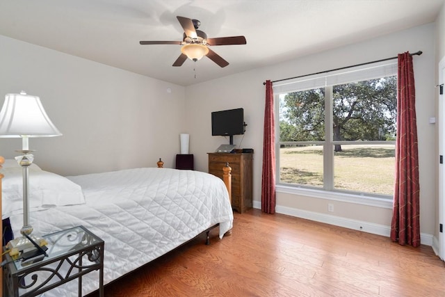 bedroom featuring multiple windows, light hardwood / wood-style floors, and ceiling fan