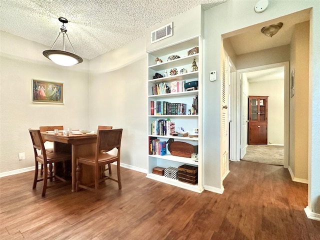 dining room featuring a textured ceiling and hardwood / wood-style floors