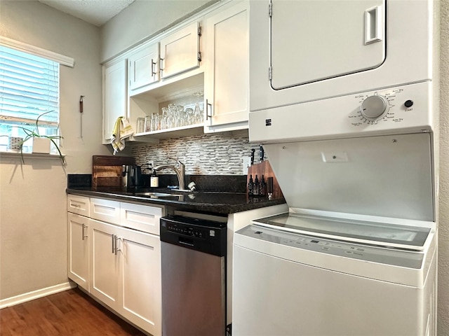 kitchen with dishwasher, stacked washer / drying machine, dark hardwood / wood-style flooring, white cabinets, and tasteful backsplash